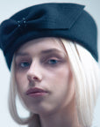 JACKIE - 1960s-style pillbox hat in black wool.